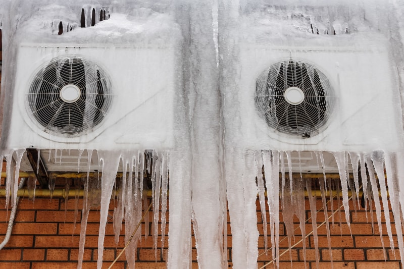two air conditioners with icicles hanging from them.