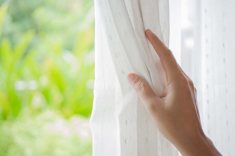 hand holding white curtain